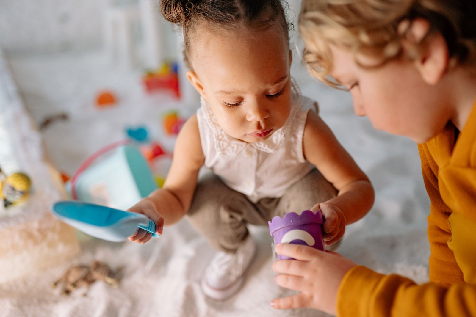 Zwei Kleinkinder spielen konzentriert nebeneinander